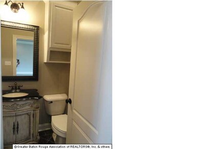 Half bath with furniture piece vanity located off 