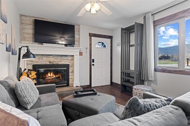 Living room with a stone fireplace, dark wood-type