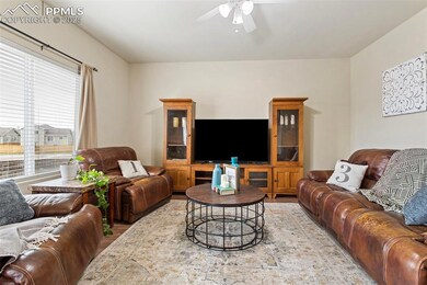 Living area with a ceiling fan and wood finished f