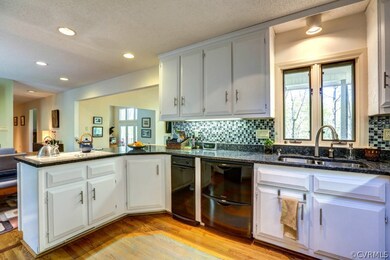 Kitchen has hardwood floors, granite countertops and under cabinet lighting