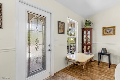 Foyer with baseboards and wood finished floors