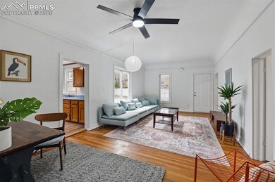 Living area featuring baseboards, a ceiling fan, a
