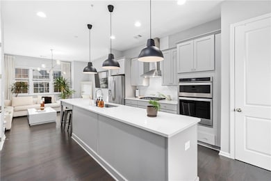 Kitchen with appliances with stainless steel finishes, decorative backsplash, light countertops, dark wood finished floors, and recessed lighting