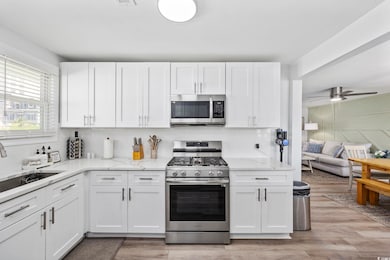 Kitchen with a sink, white cabinets, decorative ba