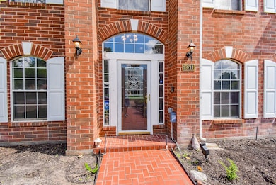 Vibrant red brick comprises the front walkway, and