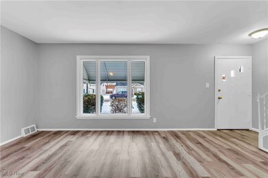 Spare room featuring light wood-style flooring, visible vents, and baseboards