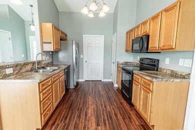 Kitchen featuring black appliances, a chandelier, 