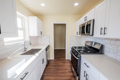 Kitchen with sink, white cabinets, decorative back