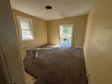 Carpeted empty room with a textured ceiling and a 
