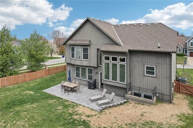 Rear view of house featuring a fenced backyard, a shingled roof, a patio, a lawn, and central AC