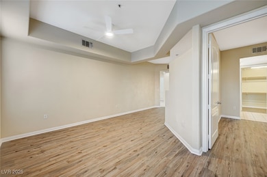 Spare room featuring a ceiling fan, baseboards, visible vents, and light wood finished floors
