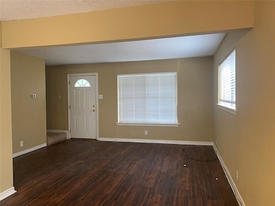 Entrance foyer featuring dark wood finished floors and a textured ceiling