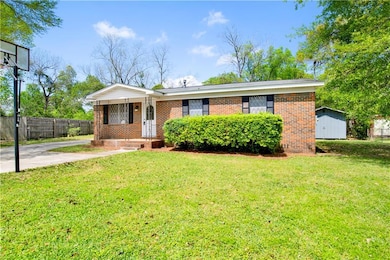 Ranch-style home with brick siding, fence, and a f