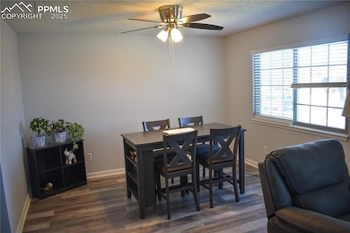 Dining room with dark wood finished floors, basebo