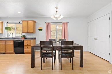 Dining space with a chandelier, light wood-style flooring, ornamental molding, and recessed lighting