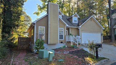 View of front facade with driveway, a chimney, an attached garage, and roof with shingles