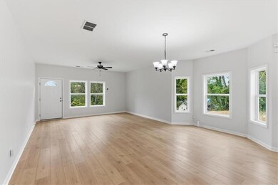 Unfurnished living room with a chandelier, ceiling fan, and light wood-style flooring
