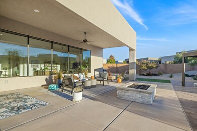 Fenced backyard with a patio, a ceiling fan, and an outdoor living space with a fire pit