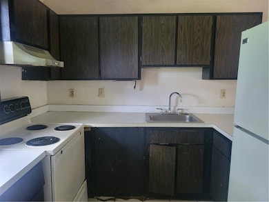 Kitchen with range, fridge, a sink, extractor fan, and light countertops