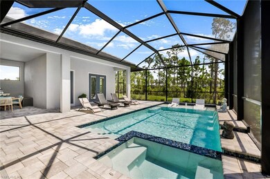 View of pool with glass enclosure, a patio, an in ground hot tub, and pool water feature