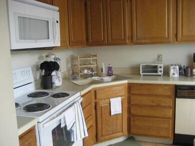 Kitchen featuring white appliances, light counter