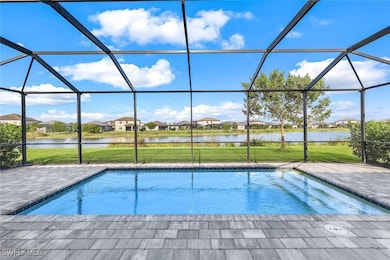 View of pool with a patio, a water view, and glass