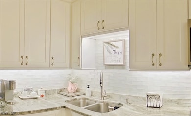 Kitchen featuring light stone counters, decorative