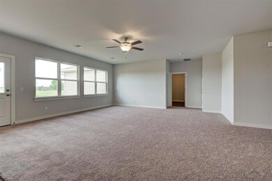Carpeted empty room with ceiling fan and baseboards