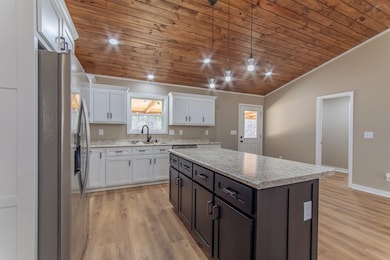 Kitchen with white cabinets, a sink, stainless ste
