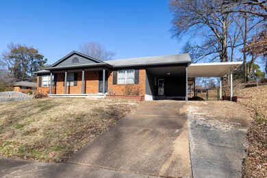 View of front of house with a carport and covered 