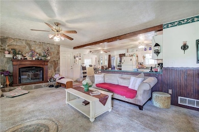 Carpeted living area featuring ceiling fan, a text