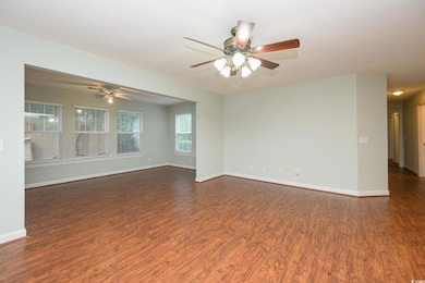 Unfurnished room with dark wood-style flooring, a textured ceiling, and a ceiling fan