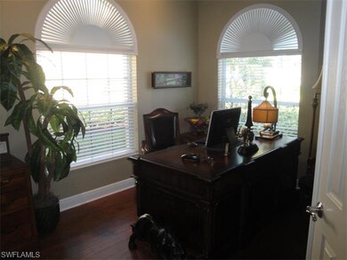 Den with custom window treatments and hardwood flo
