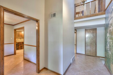 Hallway with crown molding, a textured ceiling, an