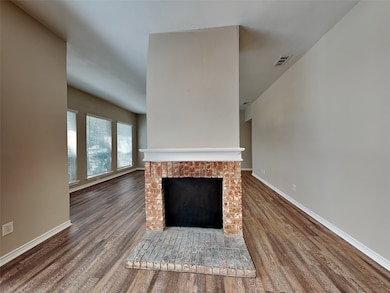 Unfurnished living room with a fireplace and dark wood-type flooring