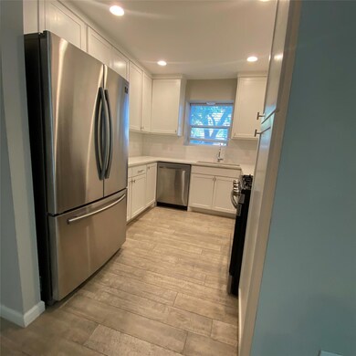 Kitchen with stainless steel appliances, light wo