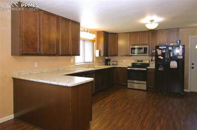 Kitchen with luxury vinyl plank flooring, a peninsula, and light countertops