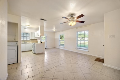 Unfurnished living room featuring ceiling fan, wa