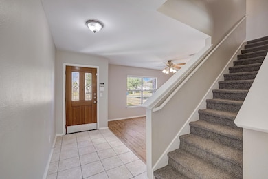 Foyer featuring light tile patterned floors and stairway