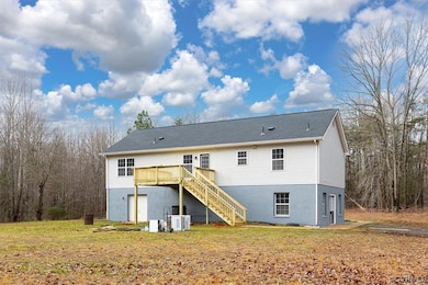 Back of house with a lawn, central air condition u