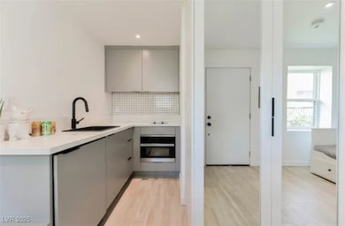 Kitchen featuring gray cabinets, oven, modern cabi
