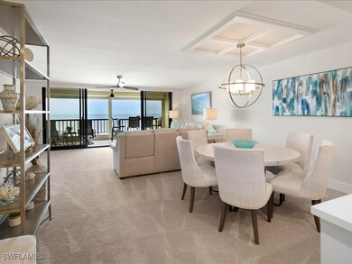 Dining area with floor to ceiling windows, a water view, light colored carpet, and a chandelier
