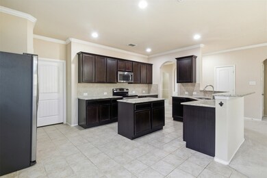 Kitchen featuring arched walkways, tasteful backsplash, stainless steel appliances, a center island, and a peninsula