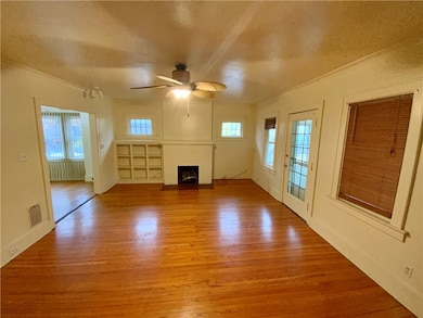 upstairs living room with built in shelves and leaded glass windows