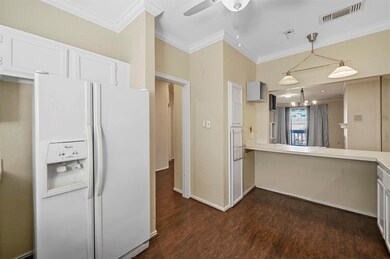 Kitchen featuring visible vents, white cabinets, l
