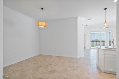 Empty room with crown molding, a water view, and light tile patterned floors