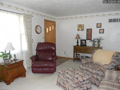 Living room features hardwood floors under carpet.