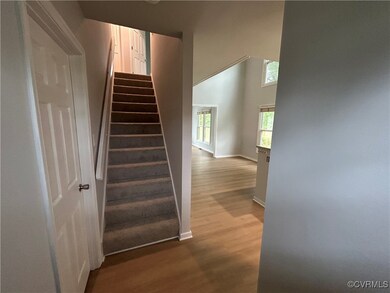 Staircase featuring wood finished floors, baseboar