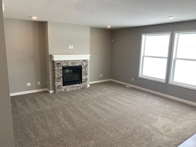 This spacious living gathering area seamlessly connects to the kitchen area, perfect for entertaining. It also features many large windows providing warm natural light. Model photo