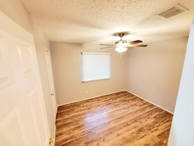 Empty room with light wood-type flooring, a textured ceiling, and ceiling fan